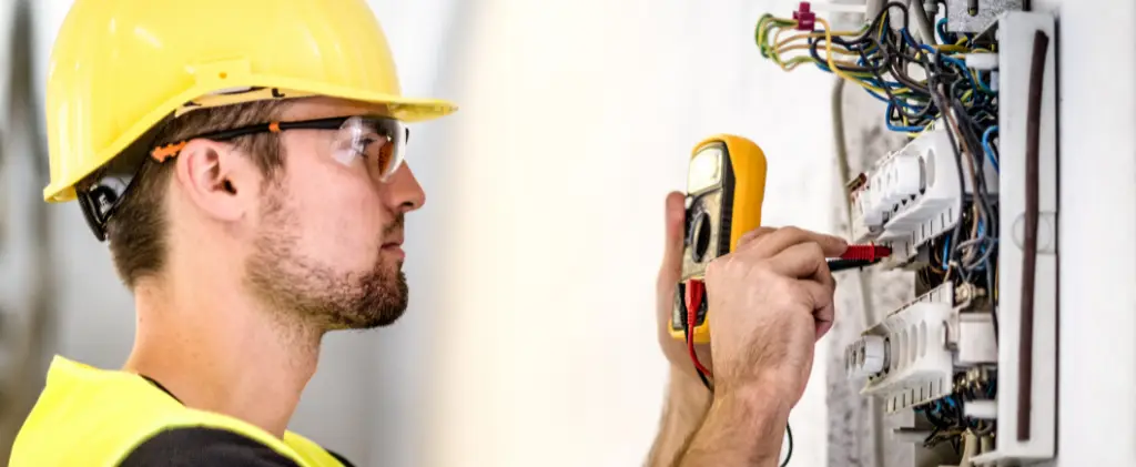 Un pro du conseil travaille sur un tableau électrique.