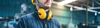 un homme portant un casque de sécurité et des lunettes de protection sur un chantier.