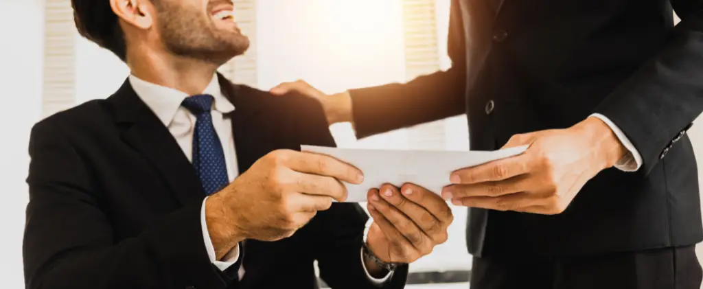 Deux professionnels échangeant un document prime énergie pro avec une poignée de main dans un bureau lumineux.
