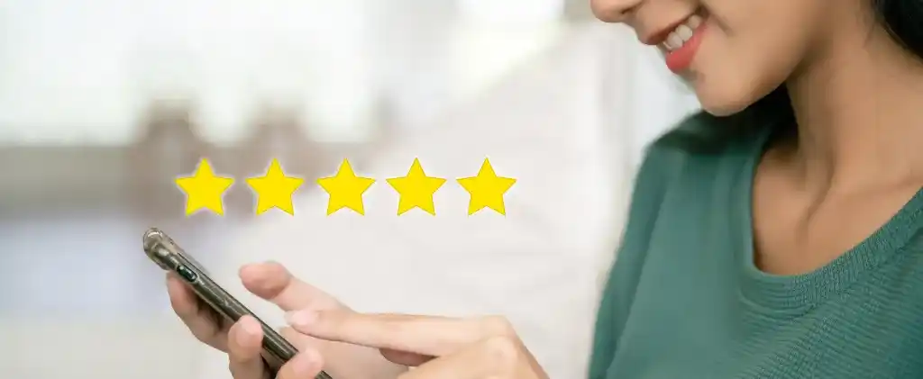 Une personne tenant un smartphone avec un graphique de note cinq étoiles affiché à côté d'elle, soulignant l'efficacité énergétique de l'appareil selon les normes de l'industrie moderne.