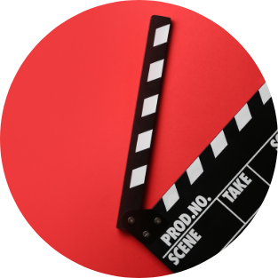 Un clap de film sur fond rouge, avec le clap relevé et les détails de production visibles, évoque l'atmosphère d'une Étude de cas : Les Cinémas de Saint-Raphaël et Capitole Énergie.