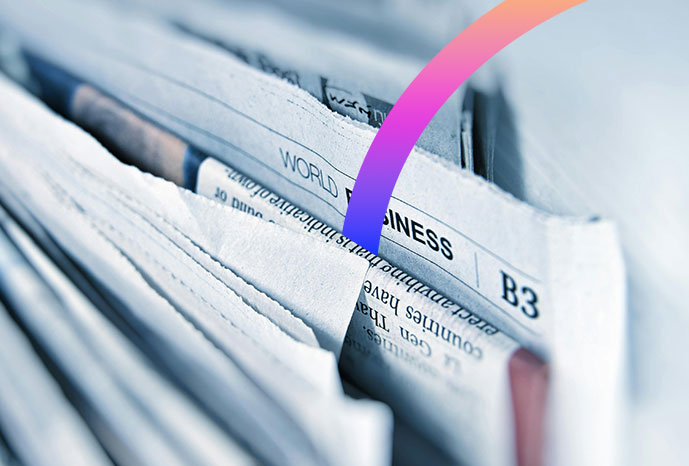 Gros plan de journaux pliés avec le titre « WORLD BUSINESS », un arc coloré sur une partie de l'image et des références subtiles à la presse capitole énergie dans la mise en page.