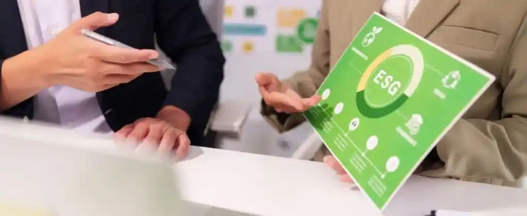 Deux personnes en tenue de travail discutent d'une infographie VNU EDF ESG (Environnement, Social, Gouvernance) à un bureau.