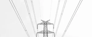 Pylône de transmission à haute tension avec plusieurs lignes électriques s'étendant dans le ciel, illustrant un nouveau mécanisme de capacité sur un fond blanc uni.