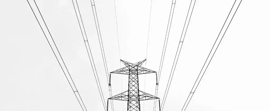 Pylône de transmission à haute tension avec plusieurs lignes électriques s'étendant dans le ciel, illustrant un nouveau mécanisme de capacité sur un fond blanc uni.