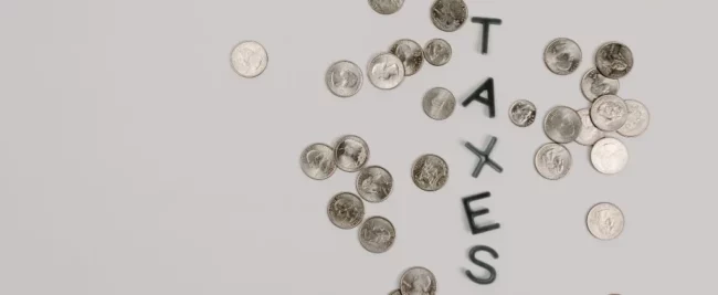Pièces de monnaie et lettres formant le mot taxes sur l'énergie en entreprise
